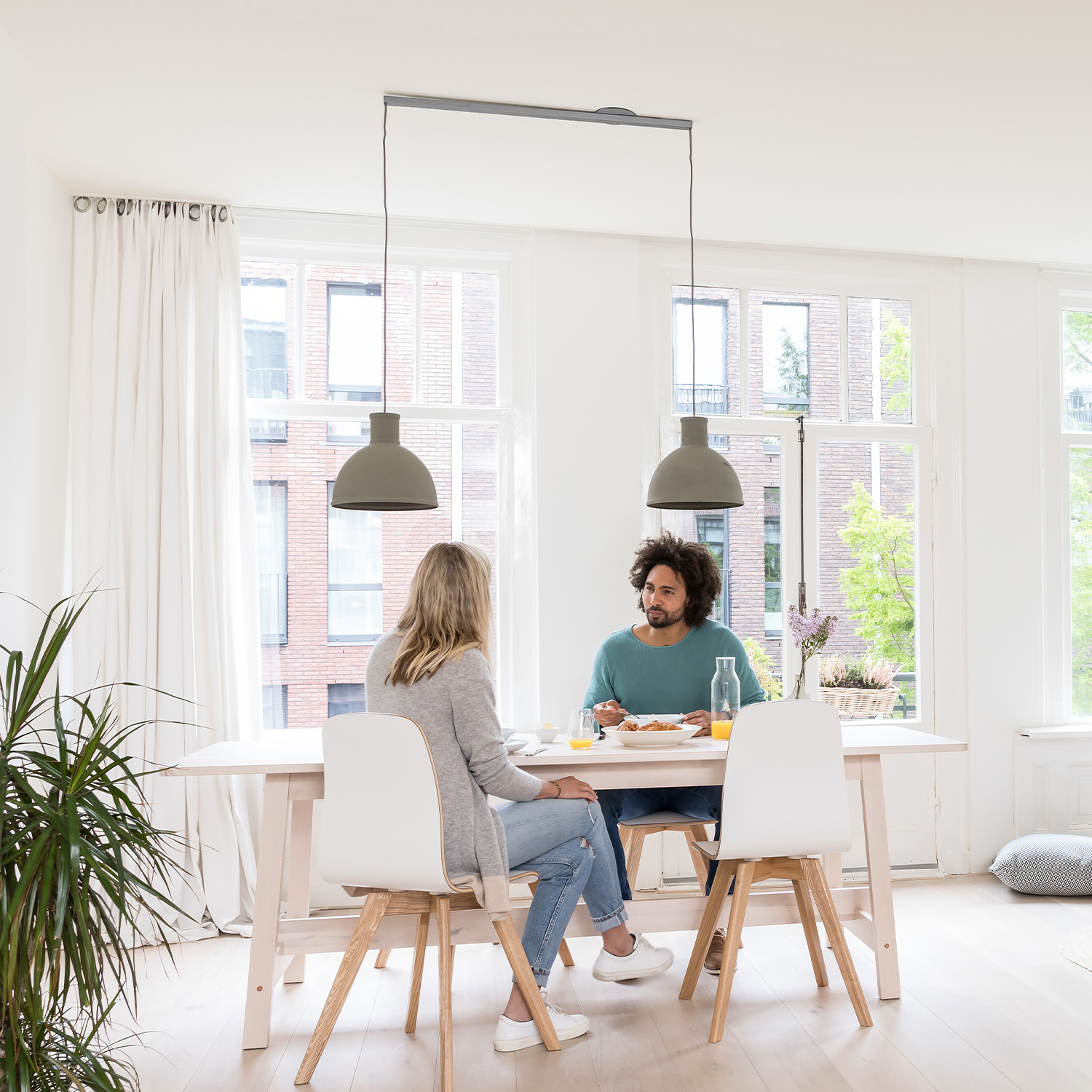 Lightswing Twin RVS in a white interior with two people at the dining table.